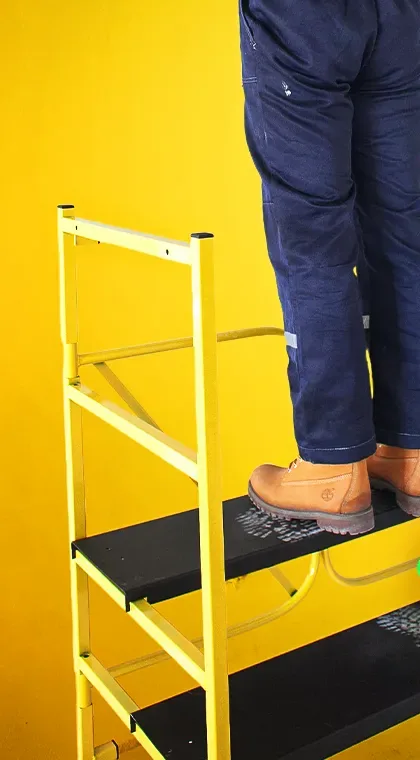 Мастер стоит на ступени подмостей StepTool СТ